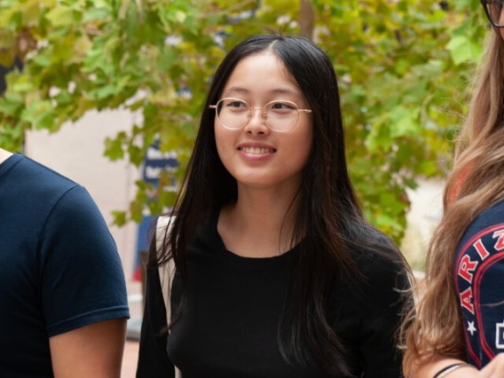 Young woman smiling and walking with classmates